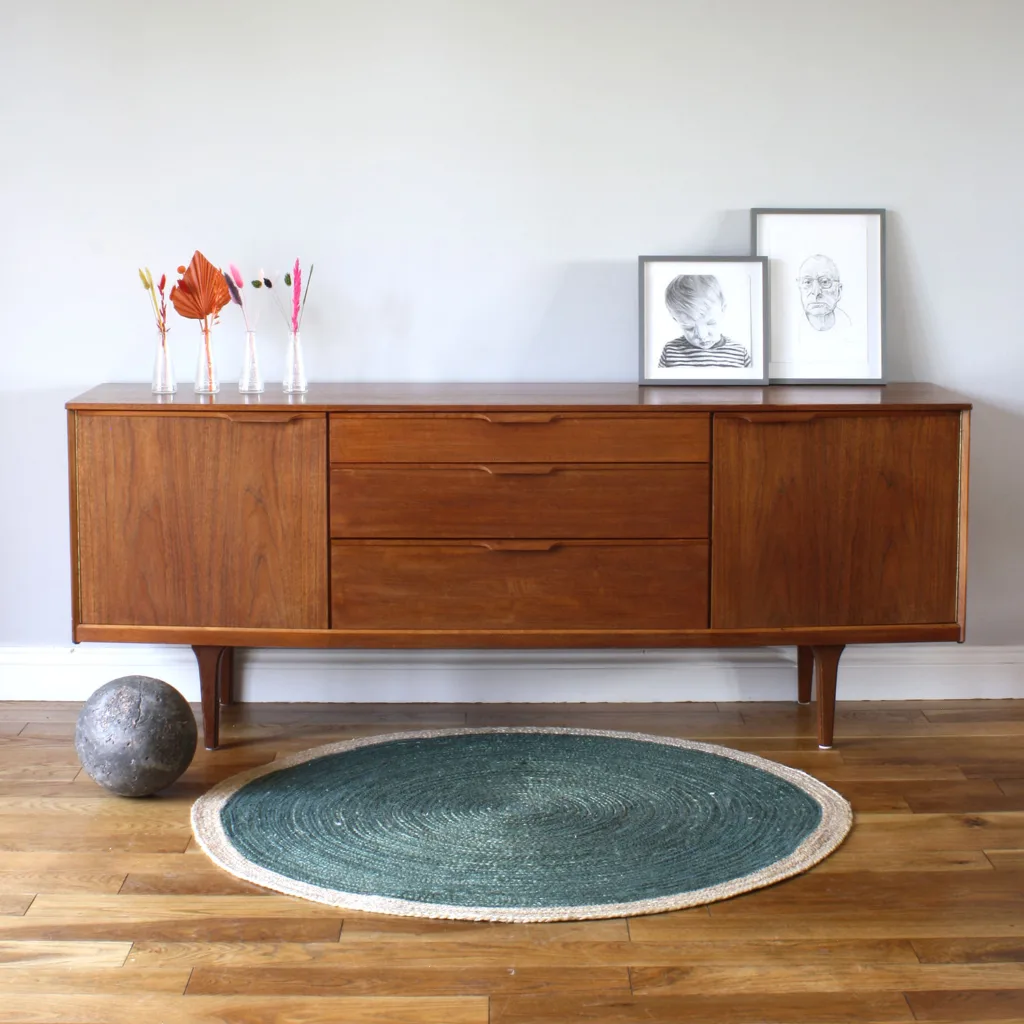 A particularly handsome, symmetrical midcentury sideboard, offering lots of storage with three drawers and two generous cupboards at either end. Made by British maker, Austinsuite, it's been thoughtfully designed and superbly constructed. This is a substantial piece of wooden furniture but the integrated slimline handles, the placement of the wood grains and the gently bowed front give it an elegance and refinement, as do the long, tapered legs.  A well-made, robust piece of vintage furniture and an attributed model seldom seen - we couldn't find another.

 

 