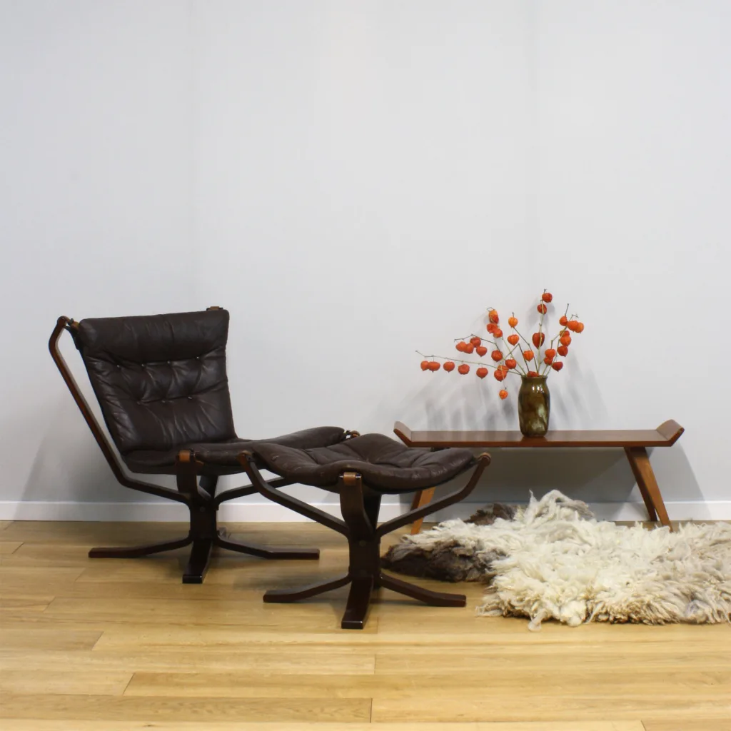 What an interesting history this handsome chair set has. At a glance, you think the iconic, Norwegian 'Falcon' chair, designed by Sigurd Ressell for Vatne Mobler in 1970. But look more closely and you'll notice that it's missing signature Falcon features... leather buckles and belts here, instead of classic metal loops; a different, smaller cushion design; and the canvas hammock seat doesn't curl round at the edges in quite the same way. It's frequently wrongly attributed when in fact it's the Danish 'Superstar' lounge chair by Genega Møbler, designed in 1973 to emulate the popular Falcon. The Vatne Møbler went on to challenge the makers of this chair design in court, wielding their patent rights, and such was the obvious imitation, they deservedly won. Production of the Superstar 'copy-cat' chair came to a somewhat abrupt halt and that was the end of its brief moment in the limelight. Staying true to its ostentatious name, the Superstar chair had its 30 seconds of fame and was withdrawn. Now with several decades of water under the bridge, this chair is as almost as desirable as the Falcon. It's a very good looking piece and an unusual, statement design with leather straps on its four corners, mooring the sling chair to the striking bentwood base. It comes with its accompanying footstool so a further bonus. Every good lounge chair deserves a footstool. They are both in cracking vintage condition and have quite the story to tell.