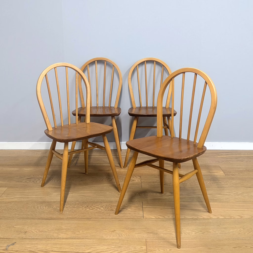 A superb quartet of 1960s Ercol Windsor dining chairs in cracking original condition - they've been cared for. Their design is smaller and less fussy than the later 400 Windsor models. With just four back spindles and a more compact seat width, their proportions are neat so ideal for a smaller table. Ercol made furniture to last and the fact these chairs are 60+ years old and still solid and stable proves that. They have much to offer and would be as at home in a midcentury dining room as they would around a homely country cottage kitchen table.