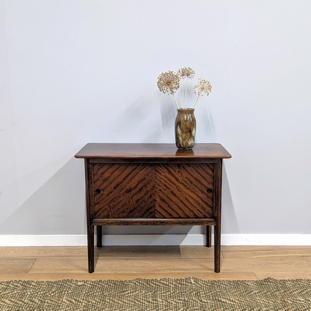 Here's a useful, little vintage piece. A smart cabinet with walnut veneer sliding doors that have a wonderfully striped grain. The dimensions are neat and tidy but it could serve well as a TV unit or media stand for a smaller television. Indeed, there are already holes in the back for leads! It comes lightly knocked and faded with life but we can forgive it that because it's a handy, little find that could slot easily into any room.