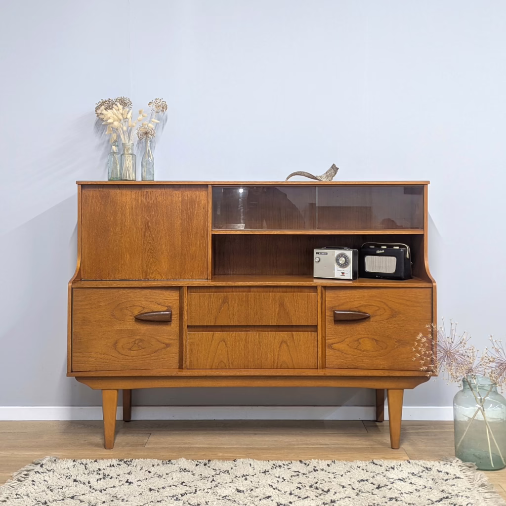 This statement midcentury high-board dates from the early 1970s and was made by  Brit maker, Jentique. It has it all going on - drinks cabinet, cutlery drawer, bookcase, shelf and storage cupboards. A multi-purpose, substantial domestic piece that covers so many practical bases. The proportions are large but it would negate the need for many individual pieces of furniture in a room. Despite its plus 50 years, it's in remarkably good order. Clearly its been loved and taken care of in its former life. Very retro and very handsome.