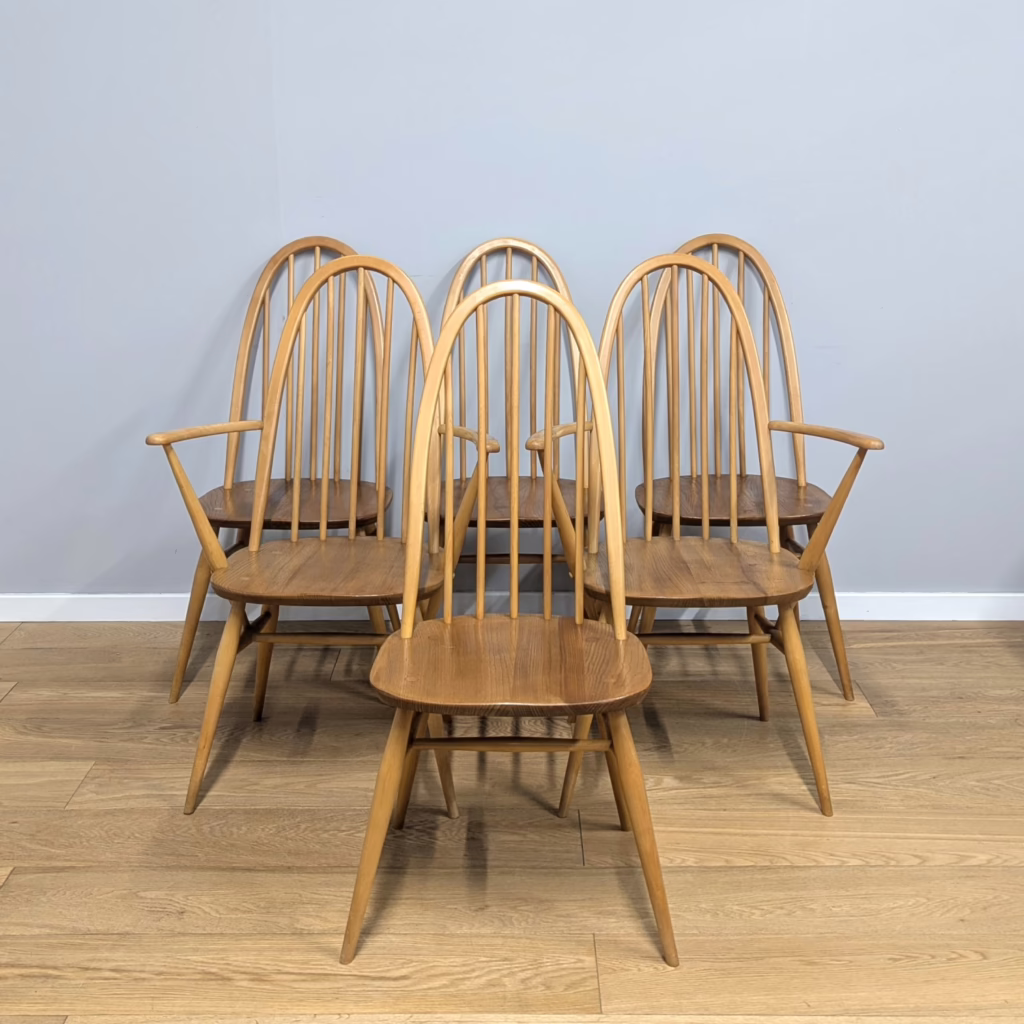 These tall, arched 'Quaker' chairs, the model 365 design, are among the most elegant of Ercol's extensive dining chair range and also some of the most sought after.  They were originally produced from the late 1950s through to the mid 1980s. Made from solid British elm and beech 'blond' woods with five-spindled backs and a generous seat height, these wider seat models offer much comfort and support round the table. This particular set is comprised of four regular dining chairs and two carver chairs with arms. They date from the late 1960s / early 1970s and are in incredible, original condition with just light signs of use. It's a rare thing to find vintage Ercol chairs in such fantastic order.